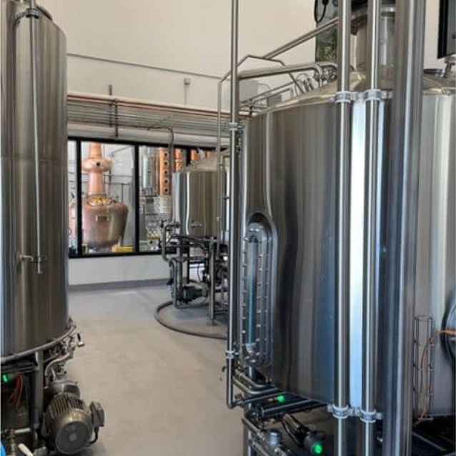 Looking from the brew house through glass windows to the distillery.