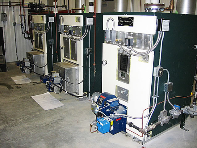 Three Columbia/Shenandoah boilers. Two boilers powered by used oil from the shop and one natural gas. Together they keep the 35,000 sq. ft. shop toasty warm fall, winter, and spring with radiant floor heat.