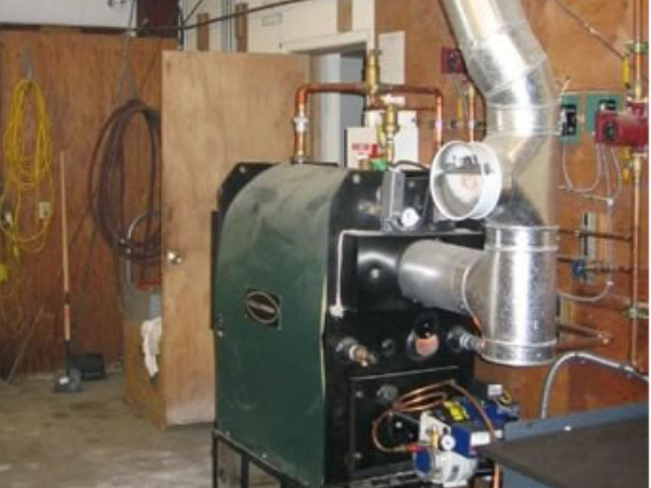 Columbia KWO 350,000 BTU waste oil fired boiler with Firelake/Shenandoah B-5 burner heats the entire facility using hot water hydronic unit heaters and hot water radiators.