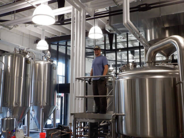 From the sidewalk, passer's by can see Sam hard at work in their brew house.