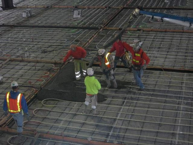 Pouring concrete over PEX tubing.