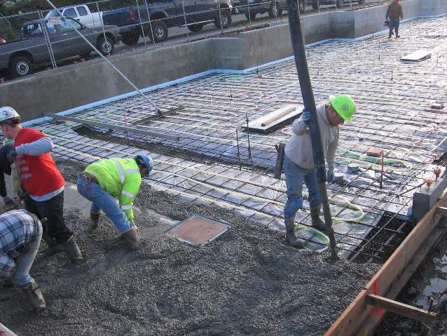Pouring concrete over PEX tubing.
