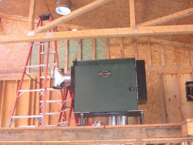 Waste oil burning boiler placed in boiler room prior to walls being installed.