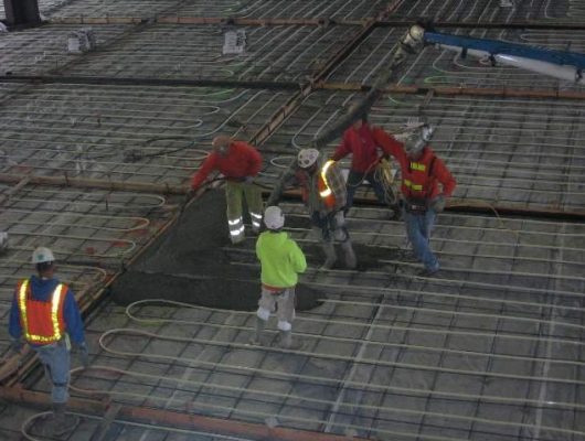 Pouring concrete over PEX tubing.